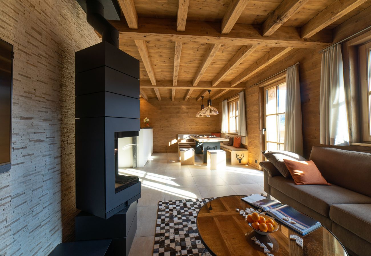 Un coin salon confortable avec un poêle à bois, un canapé, une table basse et un coin repas, dans une ambiance en bois.